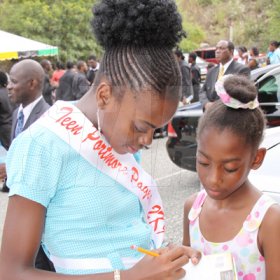 Anthony Minott/Freelance Photographer 
Miss Teen Portmore 2009, Michelle Cole (left), signs her autograph for Lannaman Preparatory's Tashanie Clarke during a celebratory service for Jamaica's Berlin World championships athletes at the Portmore Seventh Day adventist church on Saturday, October 3, 2009.
