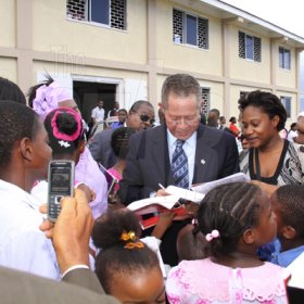 Anthony Minott/Freelance Photographer 
Prime Minister Bruce Golding (centre) signs autographs during a celebratory service for Jamaica's Berlin World championships athletes outside the  Portmore Seventh Day adventist church on Saturday, October 3, 2009.