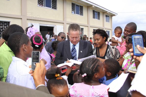 Anthony Minott/Freelance Photographer 
Prime Minister Bruce Golding (centre) signs autographs during a celebratory service for Jamaica's Berlin World championships athletes outside the  Portmore Seventh Day adventist church on Saturday, October 3, 2009.