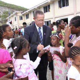 Anthony Minott/Freelance Photographer 
Prime Minister Bruce Golding signs autographs for children during a celebratory service for Jamaica's Berlin World championships athletes at the Portmore Seventh Day adventist church on Saturday, October 3, 2009.