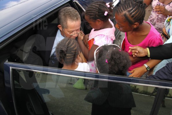 Anthony Minott/Freelance Photographer 
Prime Minister Bruce Golding (left), is flocked by children before departing the venue during a celebratory service for Jamaica's Berlin World championships athletes at the Portmore Seventh Day adventist church on Saturday, October 3, 2009.