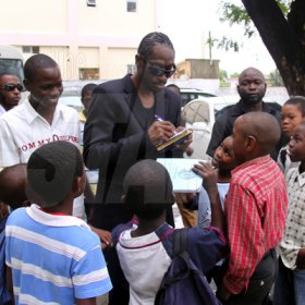 Anthony Minott/Freelance Photographer
 DJ Bounty Killer, aka Rodney Price signs autographs for children after a church service at the Agape Christian Fellowship church, located in Cedar Grove, Portmore, St Catherine on Sunday, April 18, 2010.