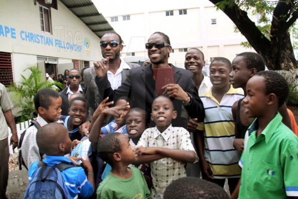 Anthony Minott/Freelance Photographer
                                                                                     Armed with a Bible in hand, Deejay Bounty Killer is all smiles as he pose with his young fans after a church service at the Agape Christian Fellowship church on Sunday, April 18, 2010.