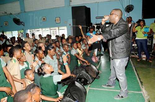 Ricardo Makyn/Staff Photographer.
Multi-talented entertainer Demarco reasons with the students during the Gleaner Champs 100 tour at St Jago High School yesterday.