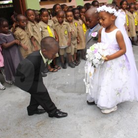 Anthony Minott/Freelance Photographer
The groom, Javier Foster (left), bows as his bride Moya Green, and her give-away father, Mark-Twaine Davidson approaches during a role play of a wedding ceremony at the Bridgeport Infant school, in Portmore, St Catherine on Friday, November 13, 2009.