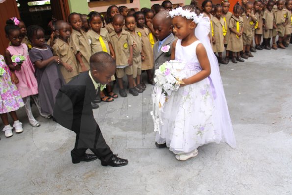 Anthony Minott/Freelance Photographer
The groom, Javier Foster (left), bows as his bride Moya Green, and her give-away father, Mark-Twaine Davidson approaches during a role play of a wedding ceremony at the Bridgeport Infant school, in Portmore, St Catherine on Friday, November 13, 2009.
