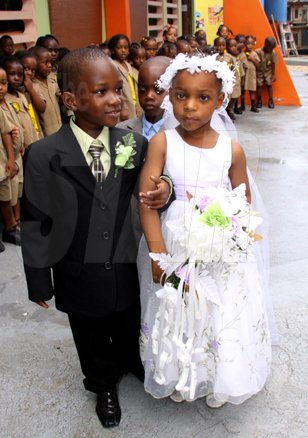 Anthony Minott/Freelance Photographer
The groom, Javier Foster (left), takes his bride Moya Green to the alter as the give away father, Mark-Twain Davidson (background), and children look on during a role play of a wedding ceremony at the Bridgeport Infant school, in Portmore, St Catherine on Friday, November 13, 2009.