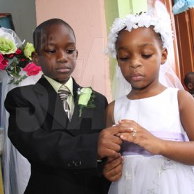 Anthony Minott/Freelance Photographer
The groom, Javier Foster (left), slips on the ring on the finger of his beautiful bride, Moya Green during a role play of a wedding ceremony at the Bridgeport Infant school, in Portmore, St Catherine on Friday, November 13, 2009.
