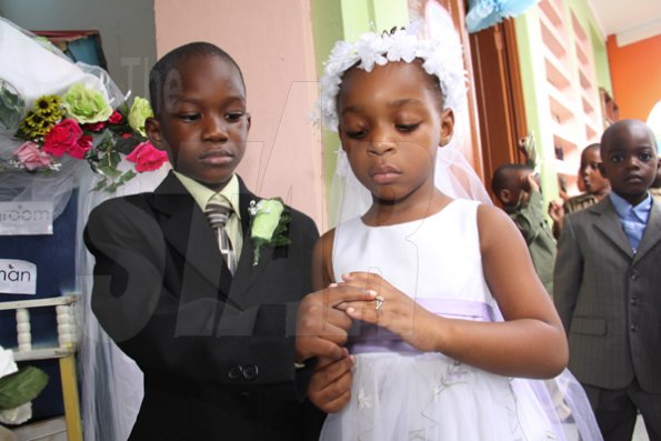 Anthony Minott/Freelance Photographer
The groom, Javier Foster (left), slips on the ring on the finger of his beautiful bride, Moya Green during a role play of a wedding ceremony at the Bridgeport Infant school, in Portmore, St Catherine on Friday, November 13, 2009.
