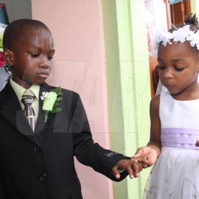 Anthony Minott/Freelance Photographer
Bride Moya Green (right), slips on the ring on groom Javier Foster during a role play of a wedding ceremony at the Bridgeport Infant school, in Portmore, St Catherine on Friday, November 13, 2009.