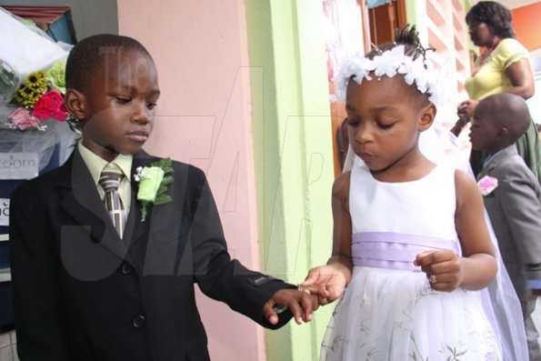 Anthony Minott/Freelance Photographer
Bride Moya Green (right), slips on the ring on groom Javier Foster during a role play of a wedding ceremony at the Bridgeport Infant school, in Portmore, St Catherine on Friday, November 13, 2009.