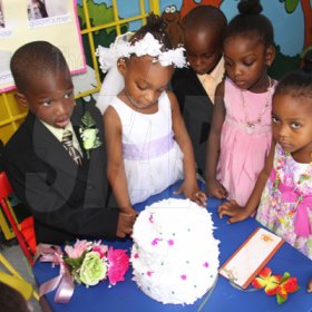 Anthony Minott/Freelance Photographer
Bride, Moya Green (2nd left), and her groom, Javier Foster (left), cuts the wedding cake, as members of the bridal party look on during a role play of a wedding ceremony at the Bridgeport Infant school, in Portmore, St Catherine on Friday, November 13, 2009.