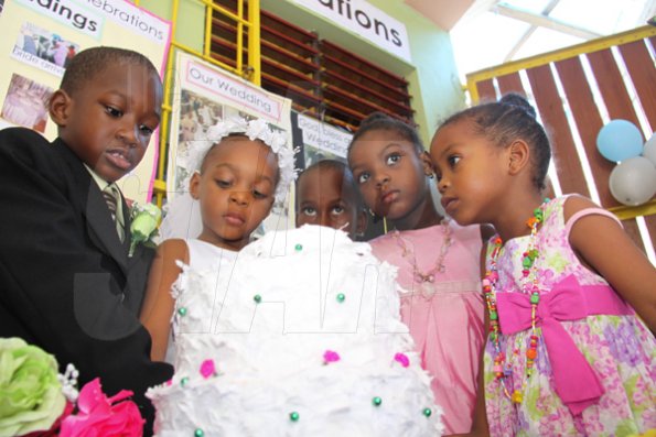 Anthony Minott/Freelance Photographer
The groom, Javier Foster, bride, Moya Green and others from the bridal party observe a cake during a role play of a wedding ceremony at the Bridgeport Infant school, in Portmore, St Catherine on Friday, November 13, 2009.