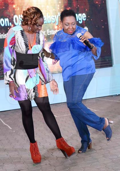 Rudolph Brown/Photographer<\n>Bussin' a dance move for our cameras are Charles Chocolates Dancin Dynamite's Producer Jenny Jenny (left) and Olivia Grange, Minister of Culture, Gender, Entertainment and Sport. <\n><\n>