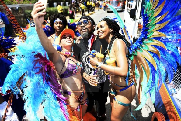 Gladstone Taylor<\n>Selfie time! Simone Mahfouz (left) and Kerah Bryant, snap a selfie with Trinidadian soca sensation Machel Montana during Xodus Carnival road march yesterday.