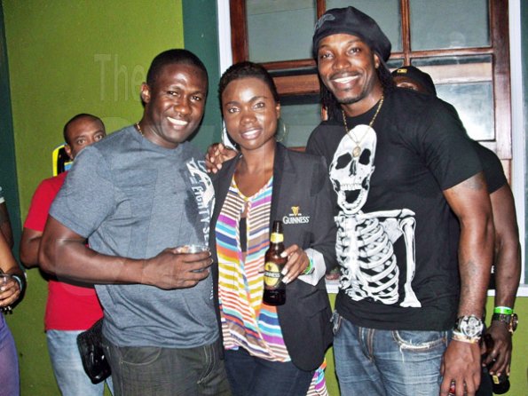 Carl Gilchrist

Guinness brand manager Racquel Nivens is hit for six, caught here between Chris Gayle (right) and Wavell Hinds, at Guinness Ochi Explosion