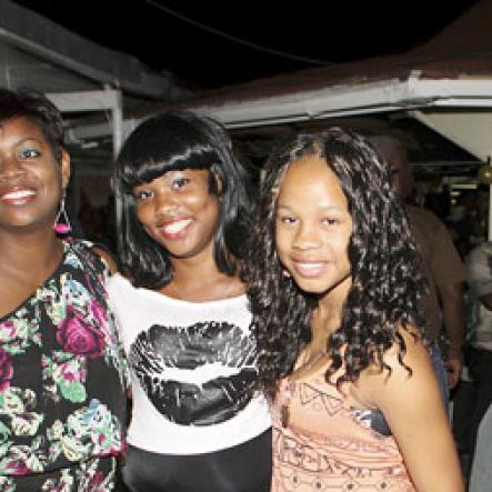 Anthony Minott/Freelance Photographer
Damion Crooks (right), son of Lester Crooks, pose with his female friends during Portmore businessman, Lester "Ken' Crooks birthnight party atop the roof of Ken's Wildflower Sports bar, Port Henderson Road, Portmore, St Catherine on Tuesday, March 13, 2012. Hundreds of patrons came to give their support.