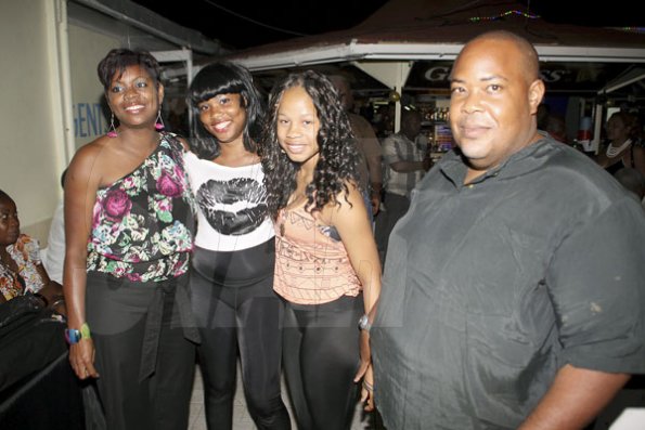 Anthony Minott/Freelance Photographer
Damion Crooks (right), son of Lester Crooks, pose with his female friends during Portmore businessman, Lester "Ken' Crooks birthnight party atop the roof of Ken's Wildflower Sports bar, Port Henderson Road, Portmore, St Catherine on Tuesday, March 13, 2012. Hundreds of patrons came to give their support.