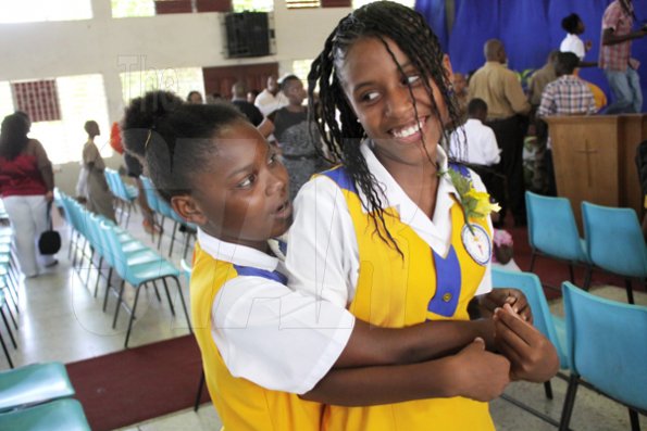 Anthony Minott/Freelance Photographer
WELL DONE! Graduate  Calise Thomas (right), gets a hug from her friend, Shanay Thomas during Glowell Preparatory School Leaving Exercise recently.
