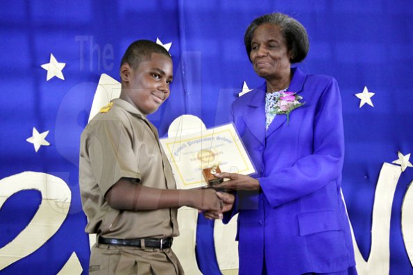Anthony Minott/Freelance Photographer
Christopher Nicholas (left), the school's top boy receives a certificate of appreciation from the school's principal, Gloria Jack  during Glowell Preparatory School Leaving Exercise recently.