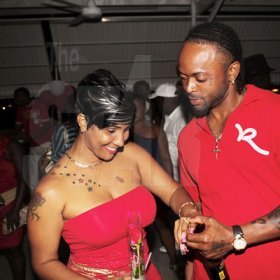 Anthony Minott/Freelance Photographer
ENGAGEMENT:  Sean Picart (right) took the occasion to slip on an engagement ring on his 'heart beat' Pamella McKenzie during Ken's Wildflower Valentine's Night party atop the roof of Ken's Wildflower Restaurant and Lounge, Port Henderson Road, Portmore Plaza, Tuesday, February 14, 2012.