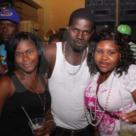 Anthony Minott/Freelance Photographer
Selector Harry Hype (centre), gets close and cozy with two female patrons during Link Up Fridays, Shortwood Road, Grants Pen, in St Andrew on Saturday night, February 3, 2012.