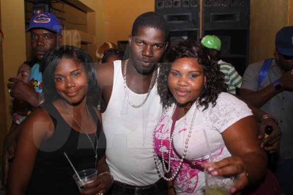 Anthony Minott/Freelance Photographer
Selector Harry Hype (centre), gets close and cozy with two female patrons during Link Up Fridays, Shortwood Road, Grants Pen, in St Andrew on Saturday night, February 3, 2012.
