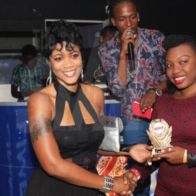 Anthony MInott/Freelance Photographer
Dancehall promoter Tamara Hollywood (left) hands over an award from a representative of Yaad Beat, which took home the Videoman of the year award  during a Magnum Portmore Dancehall Awards function at Club NTyce, Naggo Head, Portmore, St Catherine last Saturday.
