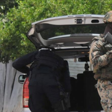 Jermaine Barnaby/Freelance Photographer
Police carrying out a check on a vehicle entering the March Pen road area on Monday October 10, 2016.
