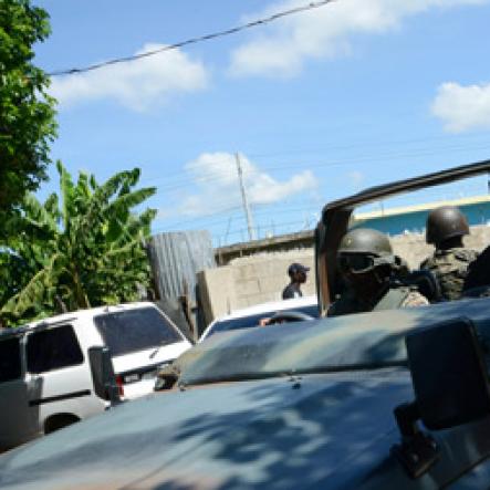 Rudolph Brown/Photographer
The Military patrolling after gunmen shoot up seven killing five including three children and set their home ablaze at Africa settlement in March Pen Community in Spanish Town on Sunday, October 9