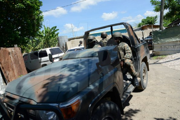 Rudolph Brown/Photographer
The Military patrolling after gunmen shoot up seven killing five including three children and set their home ablaze at Africa settlement in March Pen Community in Spanish Town on Sunday, October 9