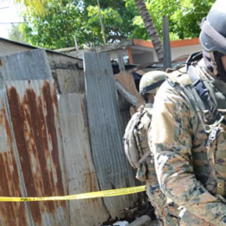 Rudolph Brown/Photographer
The Military patrolling after gunmen shoot up seven killing five including three children and set their home ablaze at Africa settlement in March Pen Community in Spanish Town on Sunday, October 9