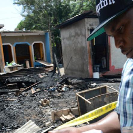 Rudolph Brown/Photographer
A police officer secure the crime scene after gunmen shoot up seven killing five including three children and set their home ablaze at Africa settlement in March Pen Community in Spanish Town on Sunday, October 9