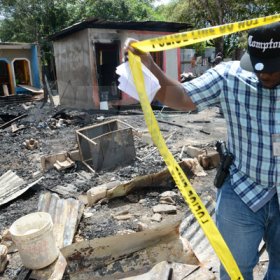 Rudolph Brown/Photographer
A police officer secure the crime scene after gunmen shoot up seven killing five including three children and set their home ablaze at Africa settlement in March Pen Community in Spanish Town on Sunday, October 9
