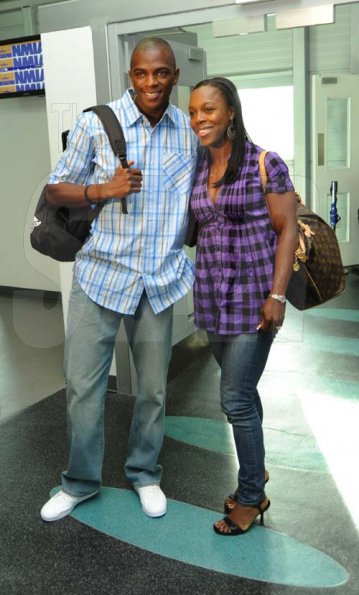 Ricardo Makyn/Staff Photographer.
World Championships silver medalist Veronica Campbell Brown and her husband Commonwealth games gold medalist Omar, pose as they arriver with other members of the Jamaican Team to Berlin at the Norman Manley International Airport yesterday.