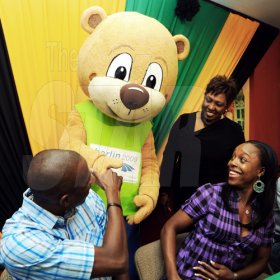 Ricardo Makyn/Staff Photographer.
 World Championship in Athletics 200m silver medallist Veronica Campbell-Brown and her husband Omar Brown, Commonwealth Games 200m champion, are greeted by World Championships mascot Berlino on their arrival at the Norman Manley International Airport in Kingston yesterday. Olivia Grange, minister of culture and sports, looks on.