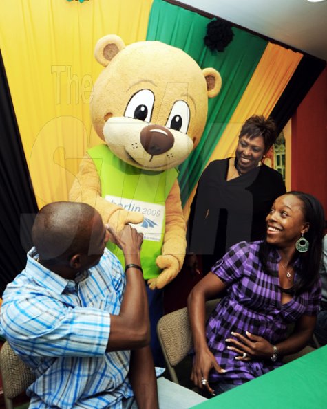 Ricardo Makyn/Staff Photographer.
 World Championship in Athletics 200m silver medallist Veronica Campbell-Brown and her husband Omar Brown, Commonwealth Games 200m champion, are greeted by World Championships mascot Berlino on their arrival at the Norman Manley International Airport in Kingston yesterday. Olivia Grange, minister of culture and sports, looks on.