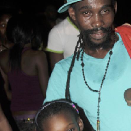 Anthony Minott/Freelance Photographer
Munga Honoureble with daughters,  Jahsenica Rhoden (left), and his  Thalia Rhoden during a Munga/Digicel back to school treat at Queens Borough, playfield, near Ackee W alk, in St Andrew recently.