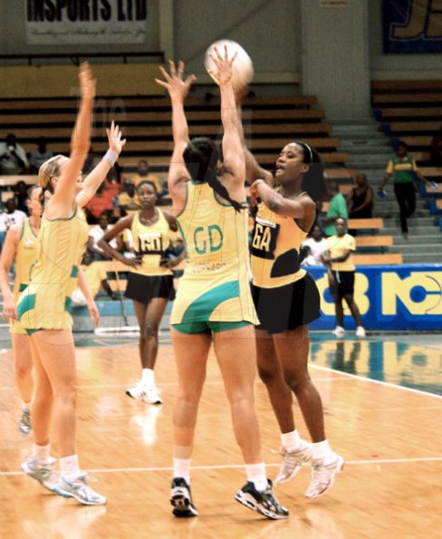 Winston Sill / Freelance Photographer
Jamaica's goal attack, Simone Forbes (right), looks to pass the ball over the hands of Australia's goal defence, Mo'onia Gerrard (second right), during the opening match of the two-Test Sunshine Series netball match, at the National Indoor Sports Centre (NISC) on Saturday. The Sunshine Girls rebounded yesterday to score an exciting 56-55 victory and tie the series 1-1. They had lost the opening game narrowly, 51-53.