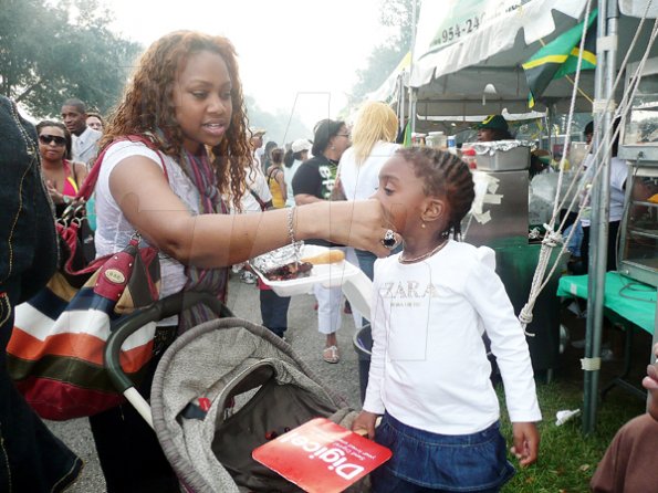 Keisha Shakespeare/Staff Reporter
Nadine Linwood-Miller gives her daughter, Alexie Miller some scrumptious jerk courtesy of Yallahs Jerk.