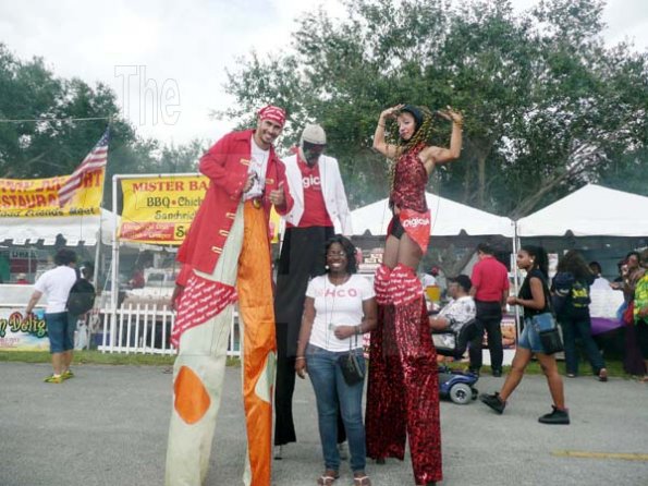 Keisha Shakespeare
Geneva Richardson (centre) get a photo opt with with Digicel stilt walkers, Rudi Goblen (left), Ty Barker (back centre), and Espy Rodriguez at the Grace Jamaican Jerk Festival.