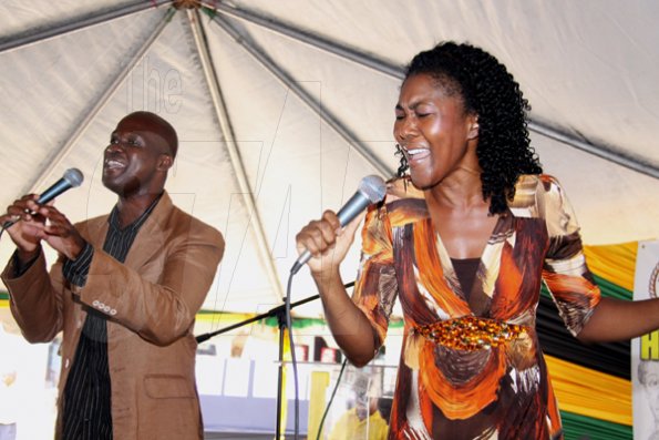 Anthony Minott/Freelance Photographer
The Gospel couple Jenieve (right) and Robert Bailey sings during a Portmore Municipal Council's Heroes Day ceremony at the Portmore Pines Plaza, Portmore, St Catherine, on Monday, October 19, 2009. A record 400-plus people attended the function.