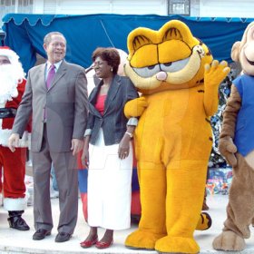Peta-Gaye Clachar/Freelance Photographer
Santa Clause played by Dr. Yeves Bergeron (left) along with Prime Minister Bruce Golding and his wife Lorna hangs out with Garfield and Coco Jam (right) at the Prime Minister's Christmas treat for children at Vale Royal on Wednesday, December 9, 2009.
