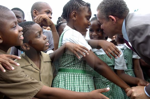 Peta-Gaye Clachar/Freelance Photographer
Prime Minister Bruce Golding greet these children with kisses at the  Christmas treat held for children at Vale Royal on Wednesday, December 9, 2009.