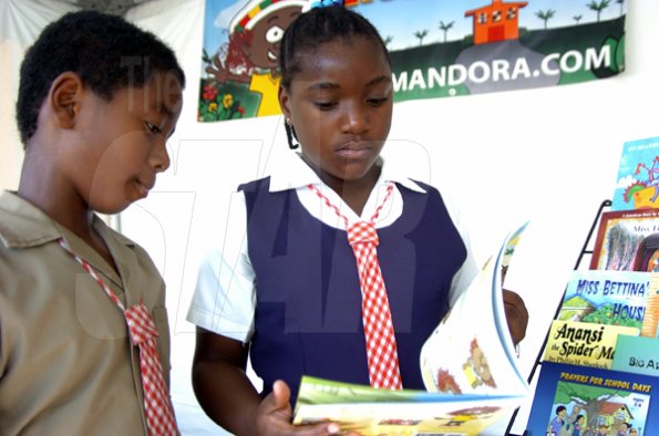 Peta-Gaye Clachar/Freelance Photographer
Jevaunie Morgan and Eisheca Gordon (right) both from the Spanish Town Primary School read stories as they browse through books at the Jamaica Library Service National Reading Fair at the Kingston and St. Andrew Parish Library on Saturday, November 28, 2009.