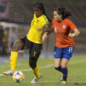 Jamaicas Khadija Shaw dribbles the ball downfield, tackled by Chile's Camila Sáez (right) in the Womens international friendly held at the national stadium on Thursday February 28, 2019.