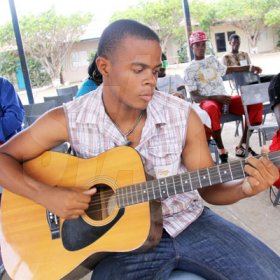 Anthony Minott/Freelance Photographer
                                                                                      Norre' Stephenson plays his guitar while awaiting a call from the judges to perform during the Digicel Rising Stars audition at the Portmore HEART Academy on Sunday, April 11, 2010.