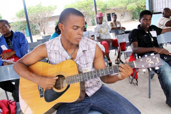 Anthony Minott/Freelance Photographer
                                                                                      Norre' Stephenson plays his guitar while awaiting a call from the judges to perform during the Digicel Rising Stars audition at the Portmore HEART Academy on Sunday, April 11, 2010.