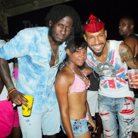 Anthony Minott/Freelance Photographer
Dancehall artiste Aidonia (left) hangs out with a female fan and artiste, King Cammar (right) before Aidonia performed on stage during Rumbar Chug it at Sugarman's Beach, in Hellshire last Sunday.
