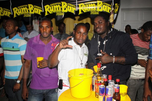 Anthoony Minott/Freelance Photographer
Container Boss, Ian Miles (centre), pose with dancehall artiste, Jah Vinci (right), and a member of the Container crew during RumBar Container Summer Party Series at Container Satdazs headquarters, Regent Street, Denham Town, in West Kingston on Saturday, July 14, 2012.
